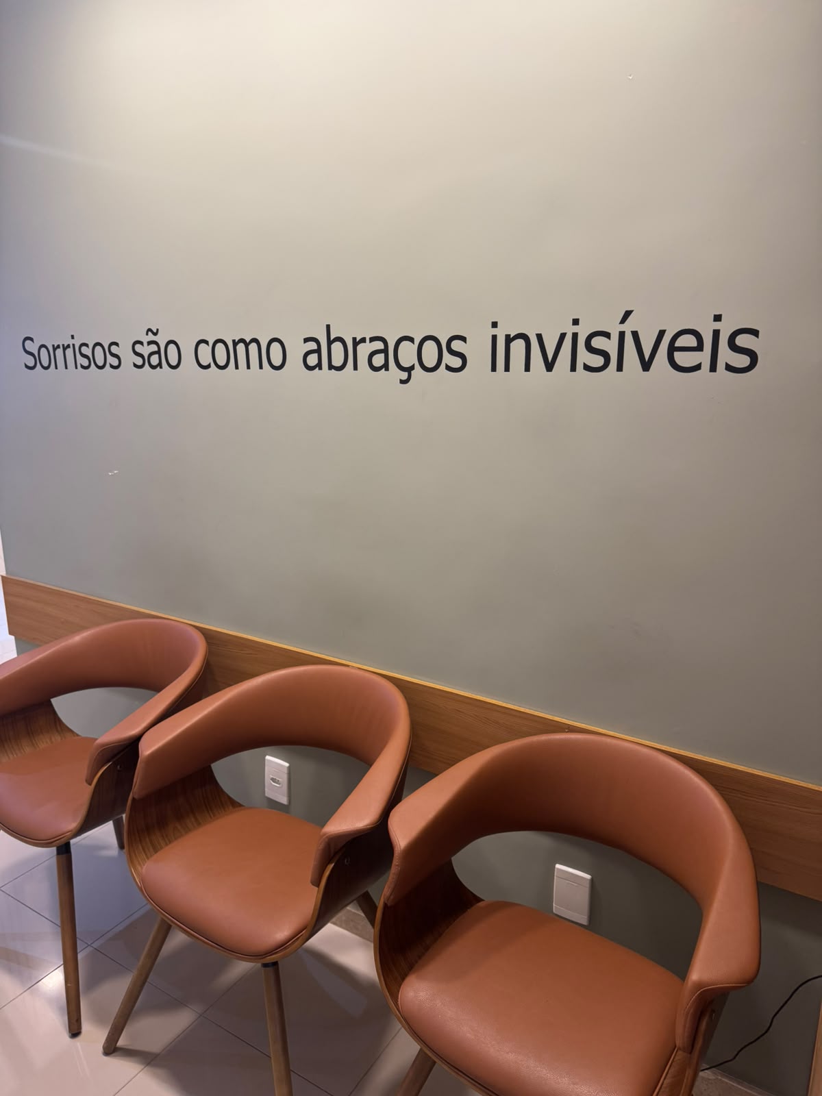 Sala de espera com a frase “Sorrisos são como abraços invisíveis”